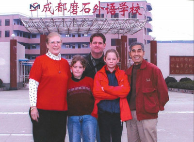 2002年，莫若健在自己创办的外语学校门前与来自美国的外教一家合影。
