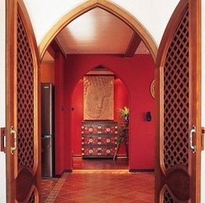 从卧室望向玄关，带尖角的拱门将石雕与彩绘的矮柜勾勒成一幅充满异域风情的图画