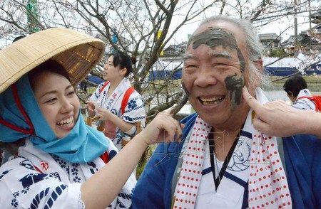 当地女子将稻田泥巴抹在男性脸上寓意祛病消灾