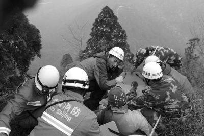 消防队员抬着担架接伤者下山。消防供图